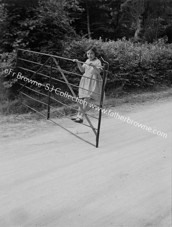 GIRL SWINGING ON GATE